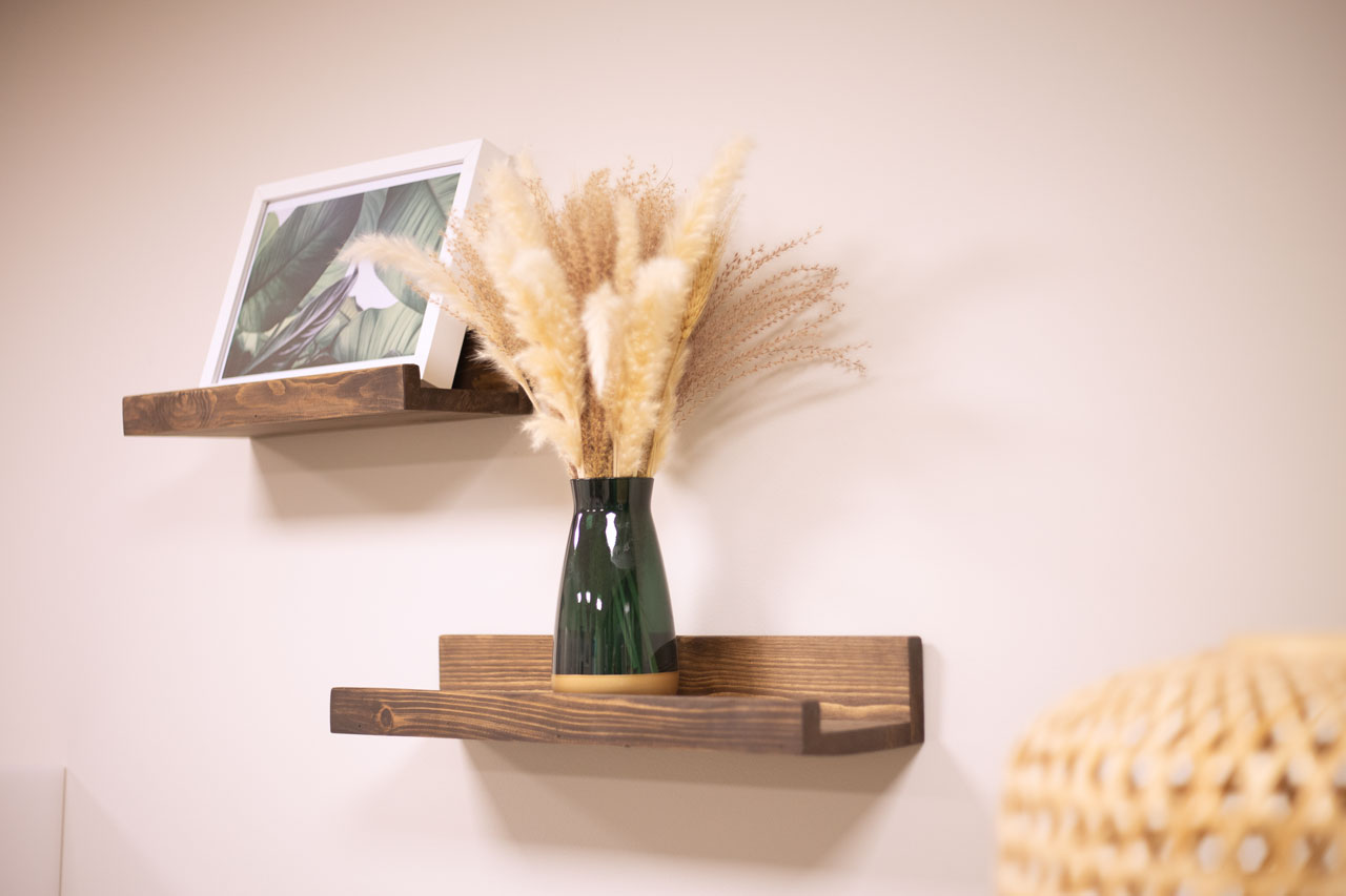 Kleine Naturholzregale mit einem Bild und einer Vase mit Gräsern
