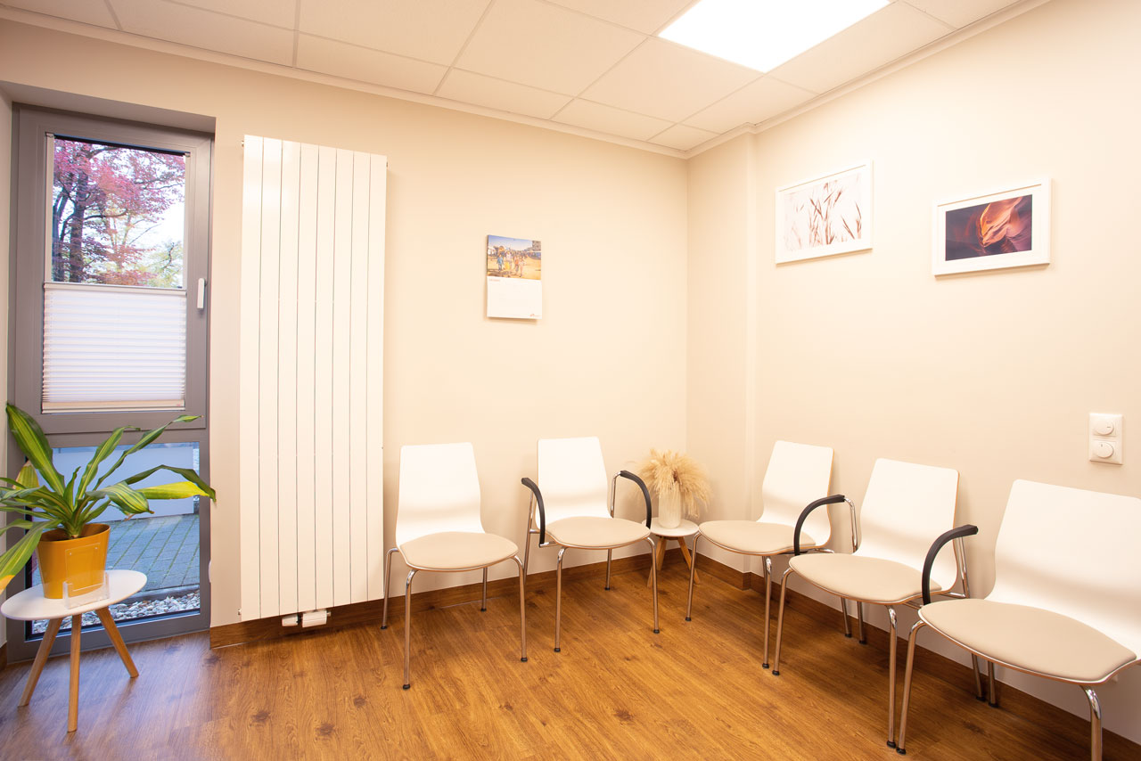 Warteraum mit Stühlen und Bildern an der Wand